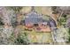 Aerial view of an estate featuring a circular driveway, brick home, patio, and detached garage surrounded by lush trees at 3074 Cascade Sw Rd, Atlanta, GA 30311