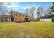 Large backyard showcasing the brick home and a detached three-car garage on a well-maintained lawn at 3074 Cascade Sw Rd, Atlanta, GA 30311