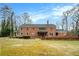 Expansive backyard featuring a large brick home with a covered patio, perfect for outdoor entertaining at 3074 Cascade Sw Rd, Atlanta, GA 30311