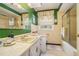 Retro-style bathroom with green walls, tan tile, a shower/tub combo, and decorative floral curtains at 3074 Cascade Sw Rd, Atlanta, GA 30311