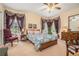 Cozy bedroom featuring curtains on large windows, soft carpet, and a bed with colorful linens at 3074 Cascade Sw Rd, Atlanta, GA 30311