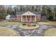 Classic brick home boasts a circular driveway, mature trees, and a timeless, elegant facade at 3074 Cascade Sw Rd, Atlanta, GA 30311