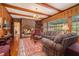 Cozy living room features a brick fireplace, wood paneling, and a large window overlooking the greenery at 3074 Cascade Sw Rd, Atlanta, GA 30311