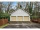 Three-car garage with white siding and yellow doors, nestled within a landscaped yard at 3074 Cascade Sw Rd, Atlanta, GA 30311