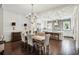 Elegant dining room open to kitchen features dark wood floors and a sophisticated chandelier at 55 Church St, Alpharetta, GA 30009
