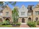 Charming townhomes showing a combination of stone and brickwork, complemented by lush green landscaping, arched doorway and small terraces at 55 Church St, Alpharetta, GA 30009