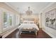 Bright bedroom with plantation shutters, chandelier lighting, neutral decor, and ensuite bath at 55 Church St, Alpharetta, GA 30009