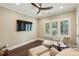 Comfortable sitting room with dark wood floors, large-screen TV, and plenty of natural light from plantation shutters at 55 Church St, Alpharetta, GA 30009