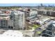 Aerial view of modern condo building with downtown skyline, local retail, and tree-lined streets at 1100 Howell Mill Nw Rd # 613, Atlanta, GA 30318