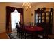 Dining room with chandelier, china cabinet and traditional table setting with red tablecloth at 5700 Thrasher Ln, Conyers, GA 30094