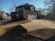 Attached garage with wide driveway and partial view of the backyard and landscaping at 5700 Thrasher Ln, Conyers, GA 30094
