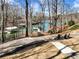 Beautiful backyard with mature trees, a patio area, and a pathway leading to the lake; perfect for outdoor entertaining at 6041 Blackberry Ln, Buford, GA 30518