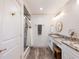 Bright bathroom featuring a walk-in shower, vanity with a granite countertop, and brushed gold fixtures at 6041 Blackberry Ln, Buford, GA 30518