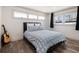 Comfortable bedroom with two windows providing lots of natural light and wood flooring at 6041 Blackberry Ln, Buford, GA 30518