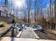 A backyard firepit area is nestled among trees and features Adirondack chairs at 6041 Blackberry Ln, Buford, GA 30518