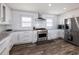 Modern kitchen featuring stainless steel appliances, granite countertops, and white cabinetry at 6041 Blackberry Ln, Buford, GA 30518