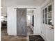 Mud room featuring a sliding barn door, built-in storage, and access to the laundry room at 6041 Blackberry Ln, Buford, GA 30518