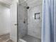 Remodeled shower featuring gray marble style tiles, hexagon floor tiles, and a convenient shower niche at 6041 Blackberry Ln, Buford, GA 30518