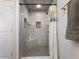 Walk-in shower featuring gray marble style tile, tiled corner seats and convenient storage niches at 6041 Blackberry Ln, Buford, GA 30518