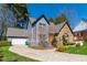 Inviting two-story home boasting stone accents, gray siding, and a well-maintained lawn leading to a garage at 7445 Talbot Colony, Atlanta, GA 30328