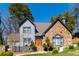Charming two-story home featuring a stone facade, gray siding, and a well-manicured lawn with mature trees at 7445 Talbot Colony, Atlanta, GA 30328