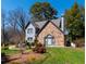 Beautiful two-story home featuring a stone facade, gray siding, and a well-landscaped front yard with mature trees at 7445 Talbot Colony, Atlanta, GA 30328
