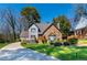 Attractive two-story home with stone and gray siding, complemented by a lush green lawn and mature trees at 7445 Talbot Colony, Atlanta, GA 30328