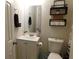 Cozy bathroom featuring a vanity with a sink, mirror, toilet, and decorative shelving for storage at 230 Laurel Way, Covington, GA 30016