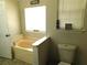 Bathroom featuring a bathtub, tile floors, and window at 230 Laurel Way, Covington, GA 30016