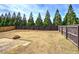 Expansive backyard features privacy fence, mature trees, and cozy fire pit area at 27 Spring Folly Nw, Cartersville, GA 30121