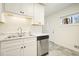 Well-lit kitchen featuring stainless steel dishwasher, sink, and white cabinets at 4985 Crowe Se Dr, Smyrna, GA 30082