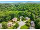 Aerial view of homes in a wooded neighborhood with mountain views in the background at 5425 Edinbourgh Ct, Cumming, GA 30040