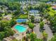 Aerial view captures the community pool, tennis courts, parking, and mature trees among residences at 5425 Edinbourgh Ct, Cumming, GA 30040