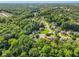 An aerial view displays a lush, wooded neighborhood from above at 5425 Edinbourgh Ct, Cumming, GA 30040