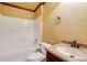 Bright bathroom featuring a tub-shower, single vanity, and earth tone textured walls at 5425 Edinbourgh Ct, Cumming, GA 30040