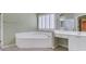 This bright and spacious bathroom offers a jacuzzi tub, double vanity, a window, and a separate door for privacy at 5425 Edinbourgh Ct, Cumming, GA 30040