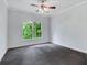 Bedroom with ceiling fan and neutral walls with a view to the wooded backyard at 5425 Edinbourgh Ct, Cumming, GA 30040