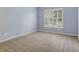A bedroom featuring a large window with natural light, neutral carpet, and soft blue walls at 5425 Edinbourgh Ct, Cumming, GA 30040