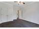 Bedroom with ceiling fan and neutral walls and carpet with walk in closet and door to the hallway at 5425 Edinbourgh Ct, Cumming, GA 30040