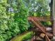 A multi-level wooden deck surrounded by lush greenery offers outdoor living space at 5425 Edinbourgh Ct, Cumming, GA 30040