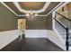 Elegant dining room with wainscoting, decorative chandelier, and hardwood floors adjacent to a staircase at 5425 Edinbourgh Ct, Cumming, GA 30040