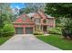 Charming two-story brick home with a well-manicured lawn and mature trees, offering great curb appeal and a welcoming ambiance at 5425 Edinbourgh Ct, Cumming, GA 30040