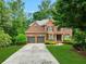 Charming two-story brick home with a well-maintained lawn and mature trees at 5425 Edinbourgh Ct, Cumming, GA 30040