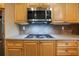 Close up of wood cabinets with granite countertops, stainless appliances and tile backsplash at 5425 Edinbourgh Ct, Cumming, GA 30040