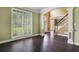 Bright and airy living room with hardwood floors, large windows with shutters, and elegant white columns at 5425 Edinbourgh Ct, Cumming, GA 30040