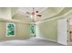 This main bedroom offers tray ceilings, a ceiling fan, multiple windows for natural light, and neutral walls at 5425 Edinbourgh Ct, Cumming, GA 30040