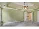 This main bedroom boasts a tray ceiling, ceiling fan, and access to an en-suite bath and adjacent living space at 5425 Edinbourgh Ct, Cumming, GA 30040