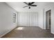 Bedroom featuring neutral carpet, ceiling fan, windows and closet spaces with doors at 3505 Miller St # D, Lithia Springs, GA 30122
