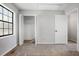 Bedroom with neutral carpet, window and open closet with clothes hanging inside at 3505 Miller St # D, Lithia Springs, GA 30122
