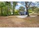 Landscaped backyard featuring a gravel pad, mature trees, and an elevated back porch at 578 Cedar Avenue, Atlanta, GA 30318